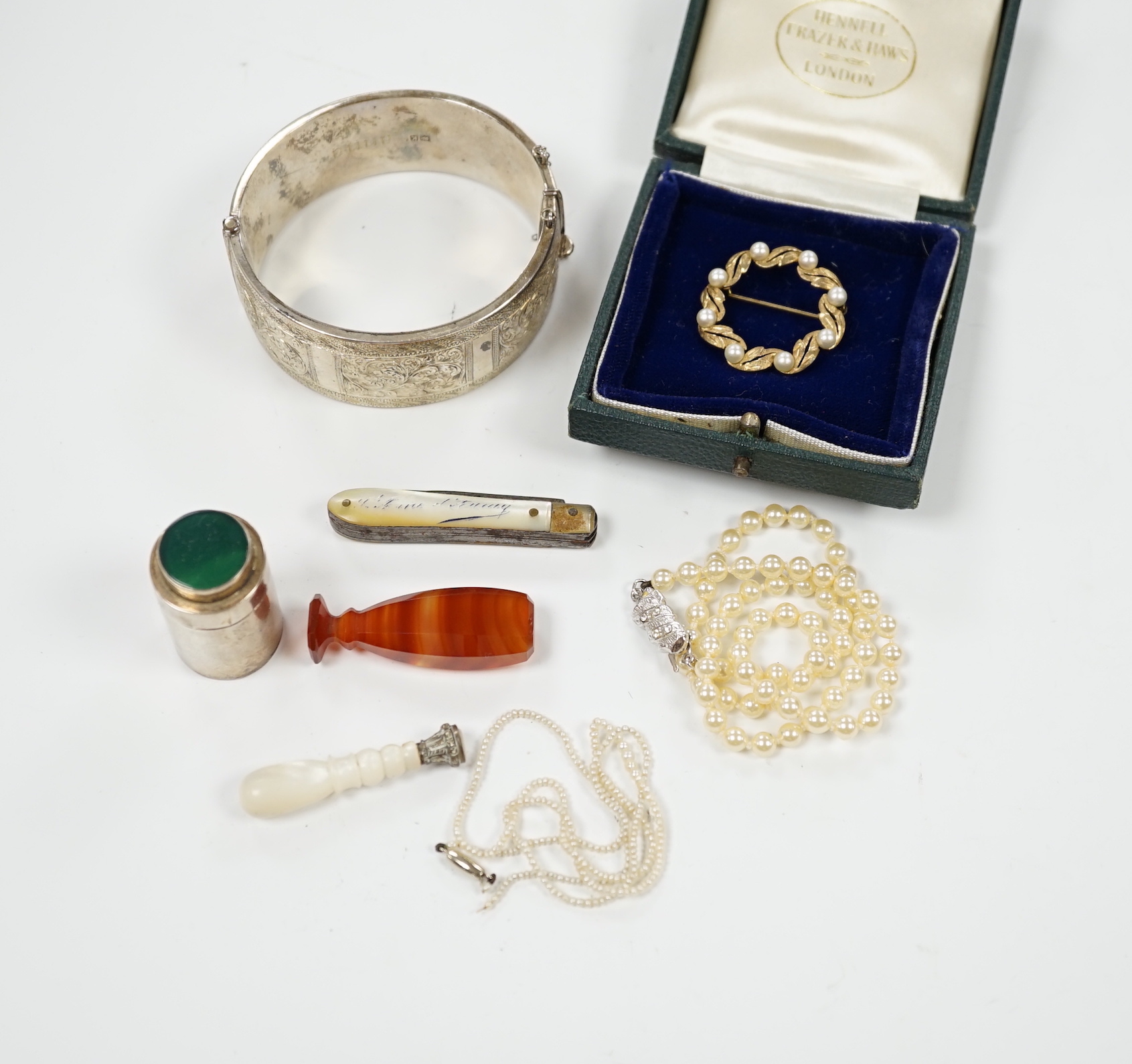 A modern 9ct gold and cultured pearl set circular brooch, 29mm, a silver hinged bangle, seed pearl necklace, a simulated pearl necklace, two seals, a 925 cannister and a pen knife.